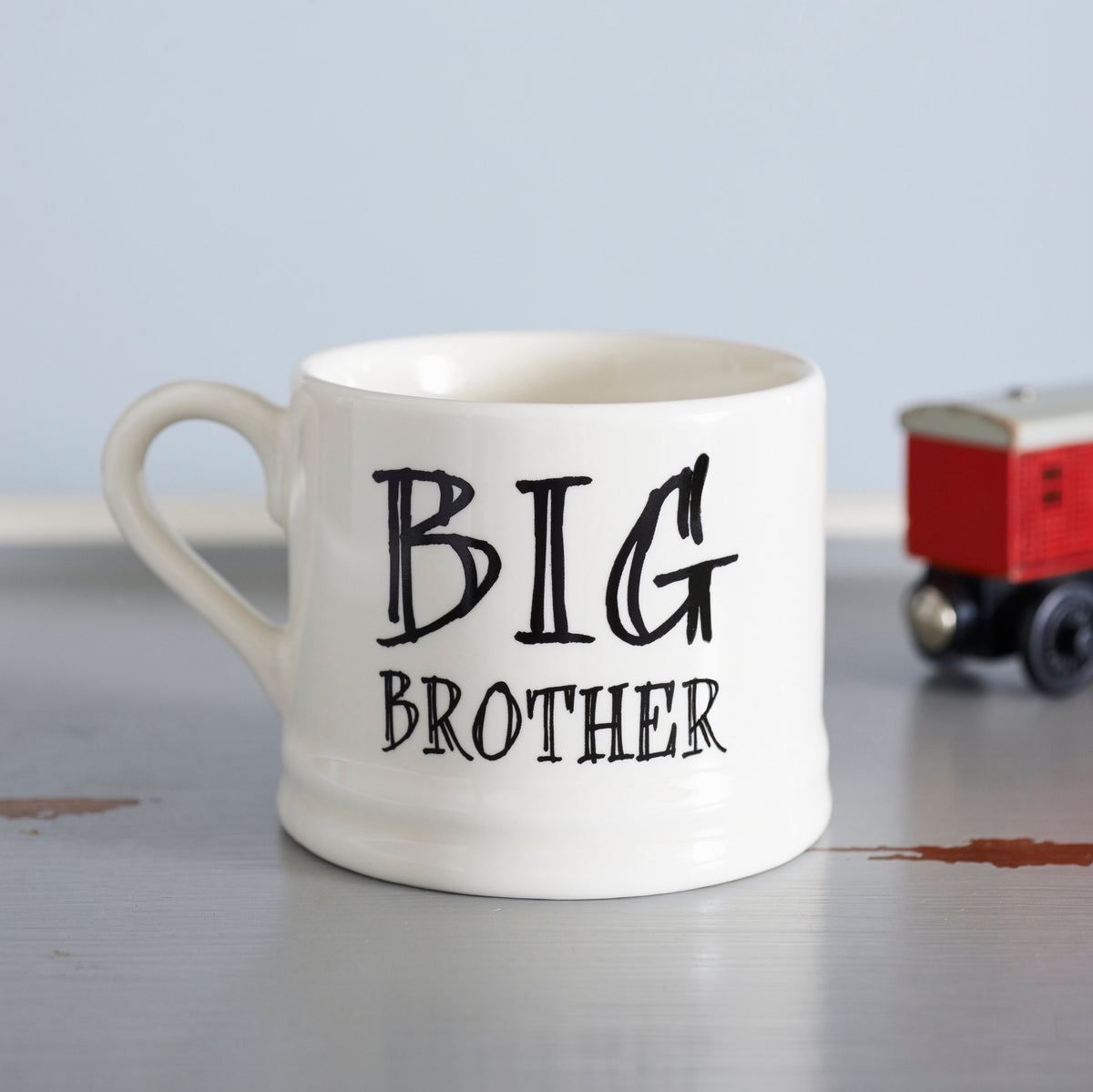 Ceramic “Big Brother” mug photographed beside a red toy train as a fun gift for a much-loved brother