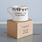 Porcelain half-cup mug on its kraft gift box, decorated with Union Jack bunting and the words, “Just half a cup for me dear”