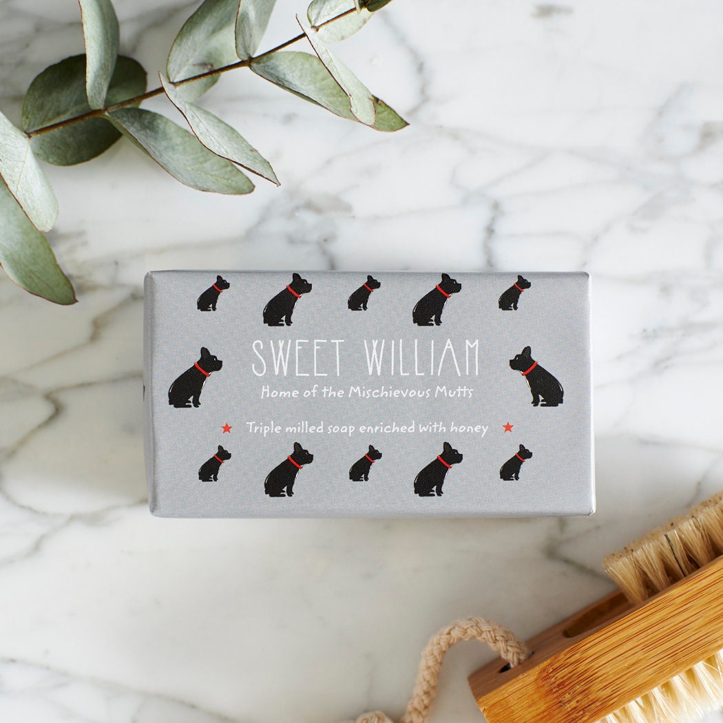Close-up of French Bulldog soap packaging — Sweet William triple milled soap enriched with honey, illustrated French Bulldog repeat pattern