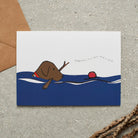 Swimming Chocolate Labrador card featuring a water-loving Chocolate Lab chasing a ball while holding a stick, with the words “Happiness is a ball and a stick” by Sweet William Designs