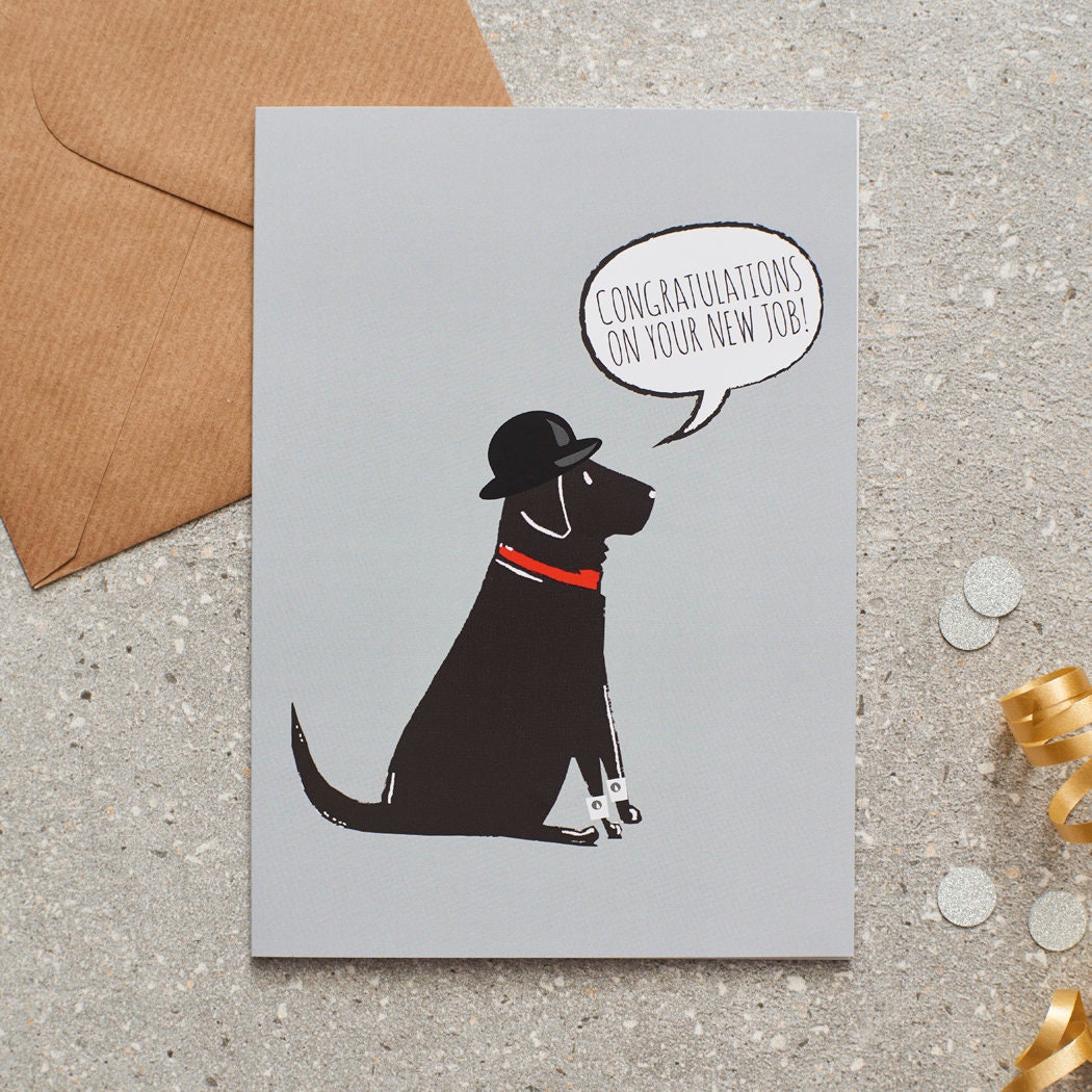 Black Labrador new job congratulations card by Sweet William Designs, featuring an illustrated Black Labrador wearing a bowler hat and red collar, with “Congratulations on your new job!” message and kraft envelope