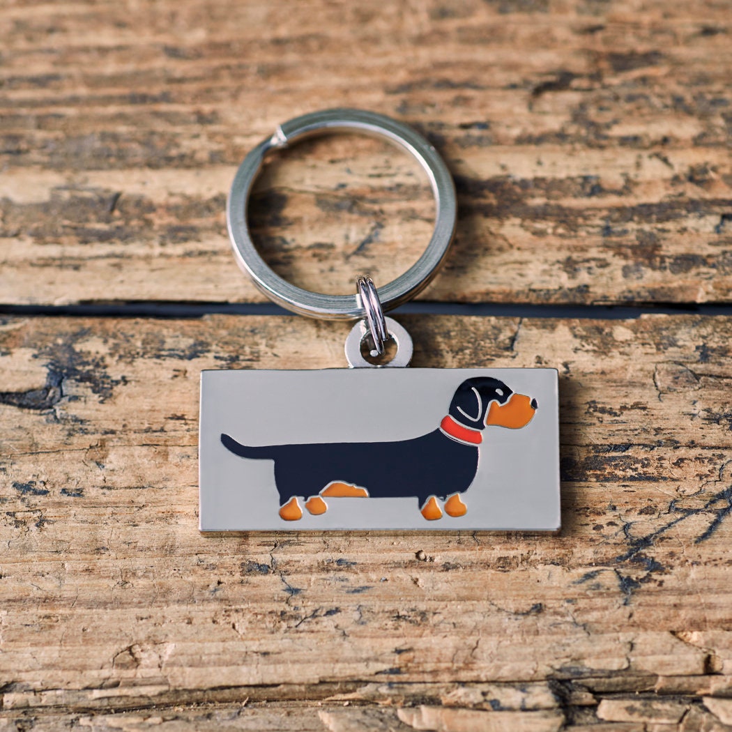 Close-up of Dachshund / Sausage Dog personalised dog tag — rectangular silver-plated brass with illustrated Daxie design, personalised dog lover gift by Sweet William Designs