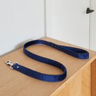 Sweet William navy velvet dog lead stretched across a wooden table, showing its handle and silver clasp