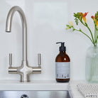Dog Walkers Revival Hand Wash on kitchen sink surface with flowers — natural hand wash, thoughtful gift for dog walkers by Sweet William Designs
