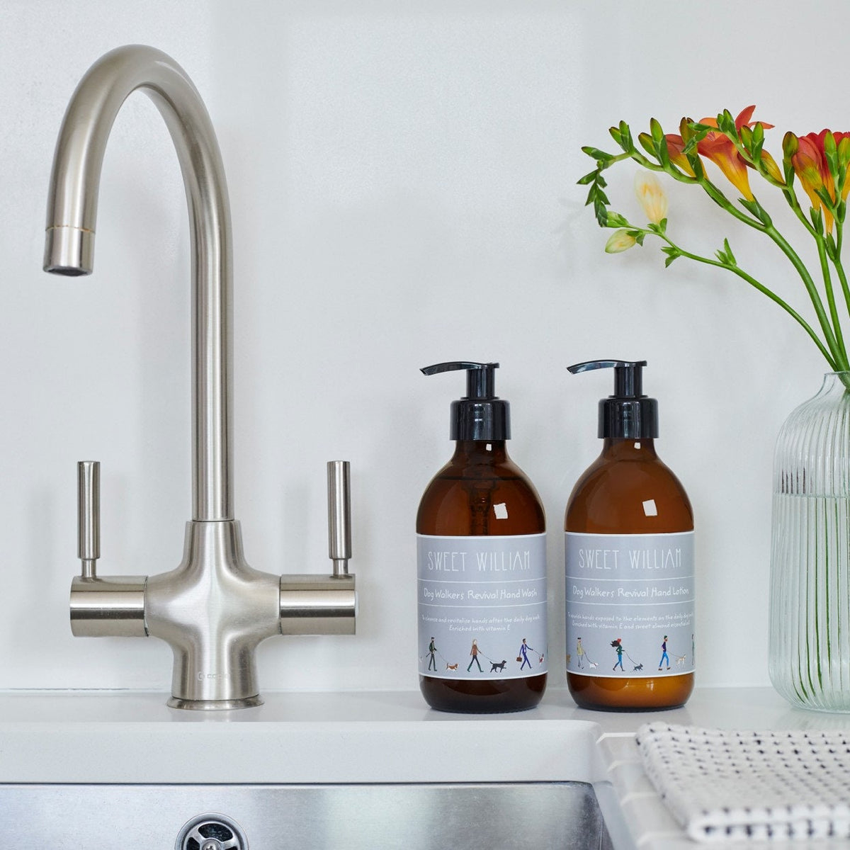 Dog Walkers Revival Hand Wash and Hand Lotion on kitchen sink with flowers — vitamin E hand care gift set for dog walkers by Sweet William Designs