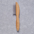 Bamboo dog comb with metal teeth on grey stone surface — dog grooming comb by Sweet William Designs