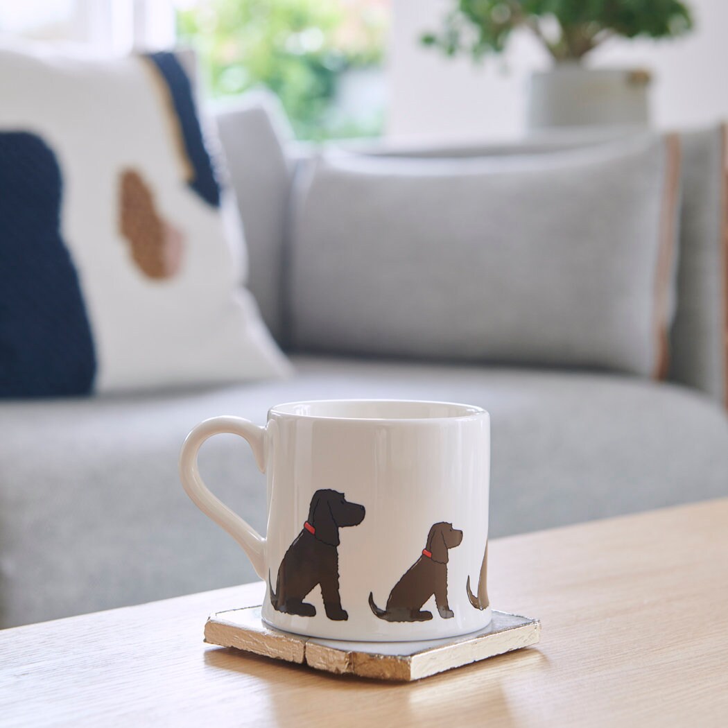Sweet William Chocolate Cocker Spaniel Mug on a coffee table — illustrated Cocker Spaniel repeat pattern ceramic mug