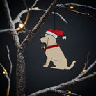 Apricot Cockapoo / Labradoodle Christmas tree decoration hanging on lit winter tree — wooden dog decoration with Father Christmas hat and jingle bell collar by Sweet William Designs