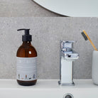 Dog Walkers Revival Hand Wash in amber glass pump bottle on bathroom surface — vitamin E hand wash, dog walker gift by Sweet William Designs