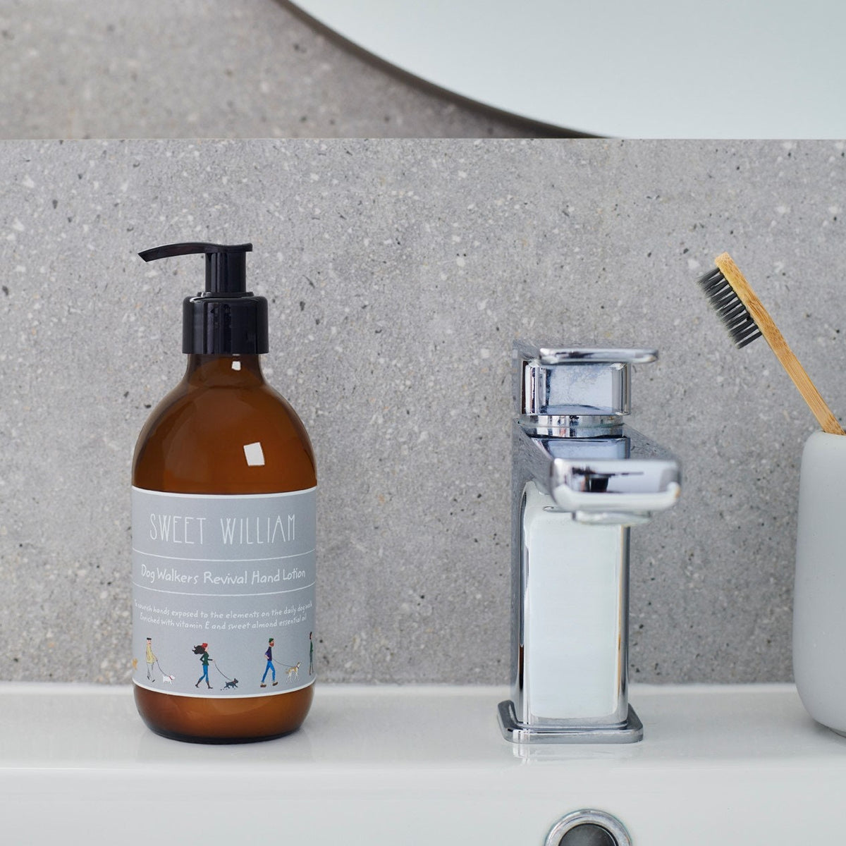 Dog Walkers Revival Hand Lotion in amber glass pump bottle on bathroom surface — vitamin E hand lotion, dog walker gift by Sweet William Designs