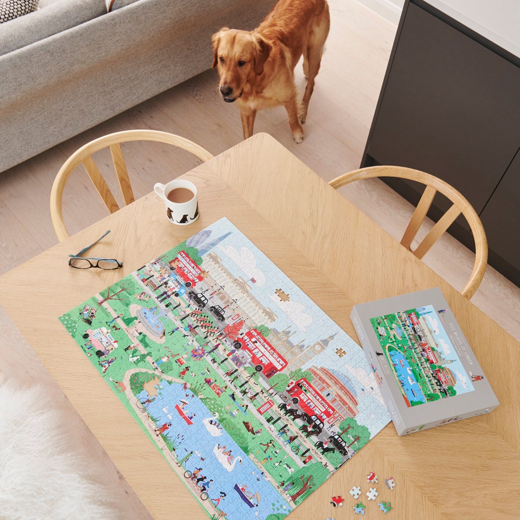 Dog Walkers of London jigsaw puzzle being assembled on a wooden table with a Cooper the golden retriever — 1000 piece London dog gift by Sweet William Designs