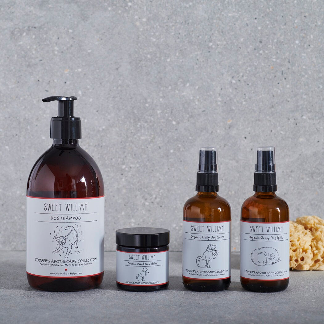 Sweet William Cooper’s Apothecary dog shampoo displayed with paw balm and daily and sleepy dog spritzes from the grooming collection
