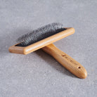 Bamboo slicker brush on grey stone surface — dog grooming brush by Sweet William Designs