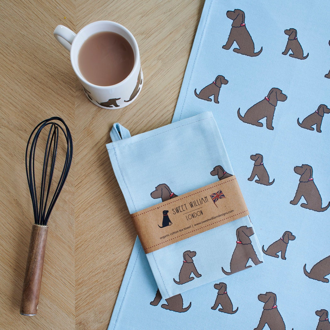 Organic cotton Chocolate Cocker Spaniel tea towel on a wooden table with a matching mug — organic cotton screen printed kitchen gifts for dog lovers by Sweet William Designs.