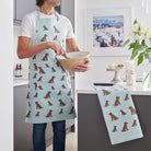 Organic cotton Chocolate Cocker Spaniel tea towel with a matching apron, styled as a coordinated kitchen set —  kitchen gift for dog lovers by Sweet William Designs.