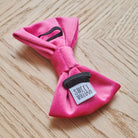 The reverse of the pink velvet dog bow tie, showing its collar loops and Sweet William label