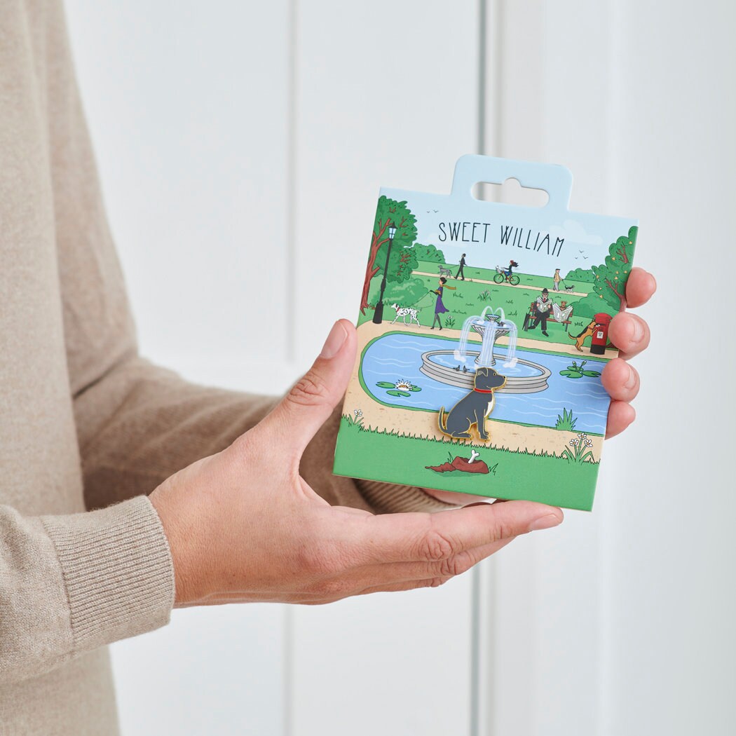 Staffie enamel dog pin held in hands on illustrated park backing card — gold-plated dog lover gift by Sweet William Designs