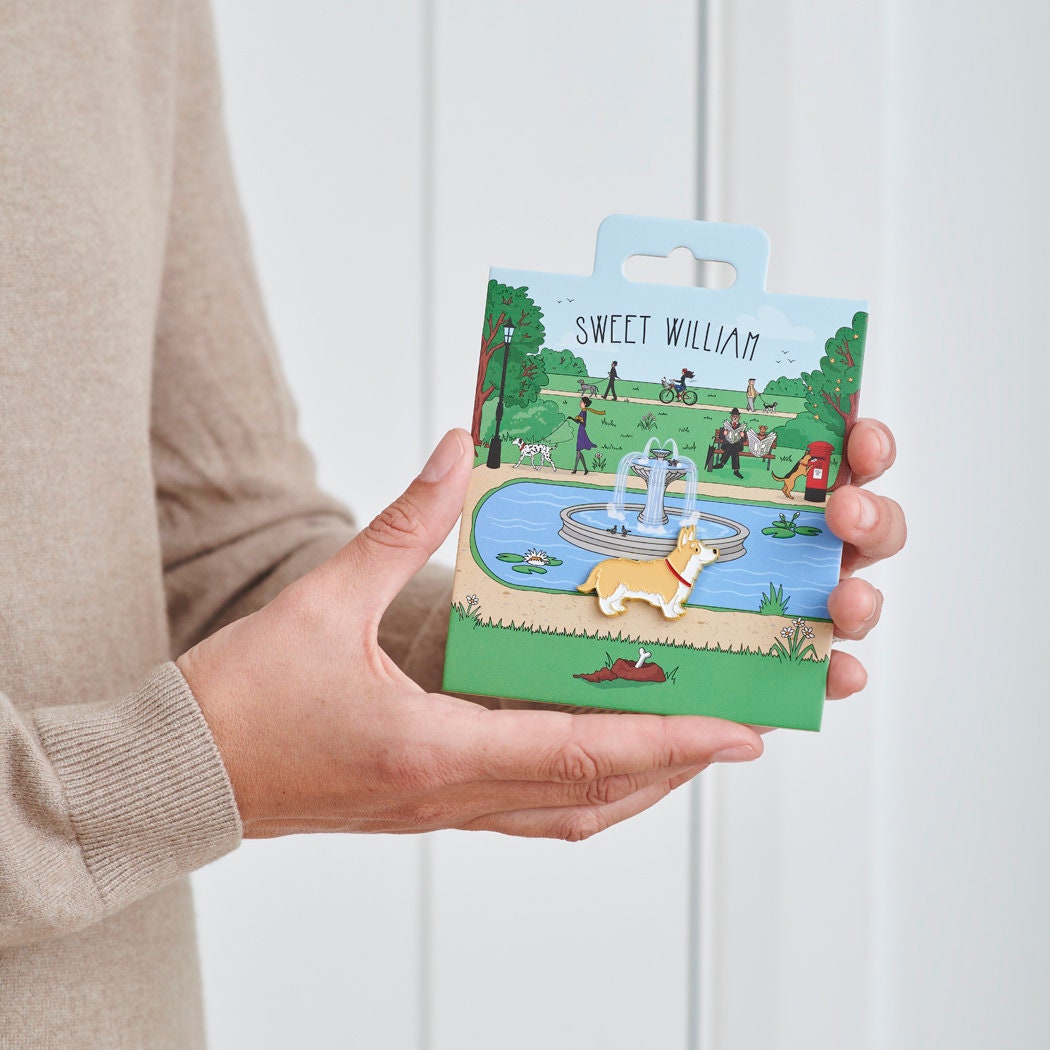 Corgi enamel dog pin held in hands on illustrated park backing card — gold-plated dog lover gift by Sweet William Designs