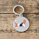 Close-up of Basset Hound dog ID tag — silver-plated brass with illustrated Basset Hound design, personalised dog tag by Sweet William Designs