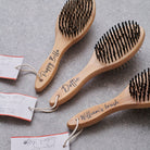 Three bamboo double sided dog brushes fanned out on grey stone — personalised with names, dog grooming gift by Sweet William Designs