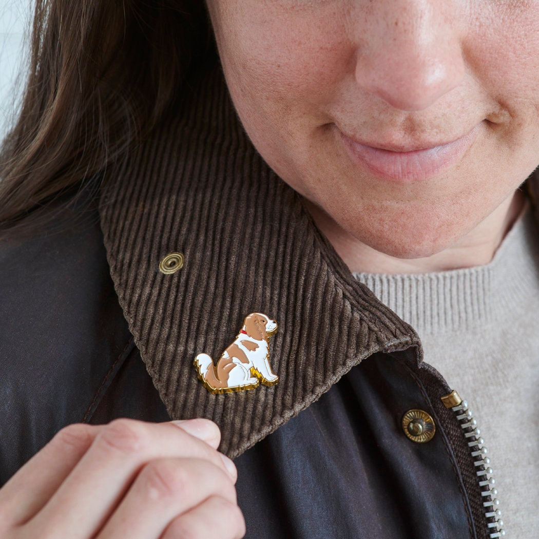 Close-up of Cavalier King Charles Spaniel enamel pin being attached to a corduroy jacket collar — gold-plated dog lover gift by Sweet William Designs 