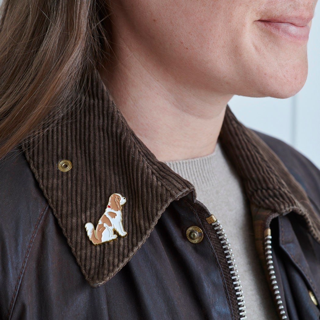 Cavalier King Charles Spaniel enamel pin worn on a corduroy jacket collar — gold-plated dog pin, perfect gift for dog lovers