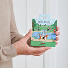 Basset Hound enamel dog pin held in hands on illustrated park backing card — gold-plated dog lover gift by Sweet William Designs