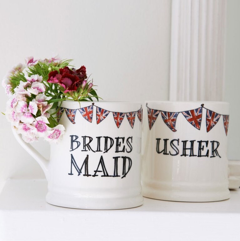 Bridesmaid and Usher mugs with Union Jack bunting, displayed together beside flowers as thoughtful wedding keepsakes