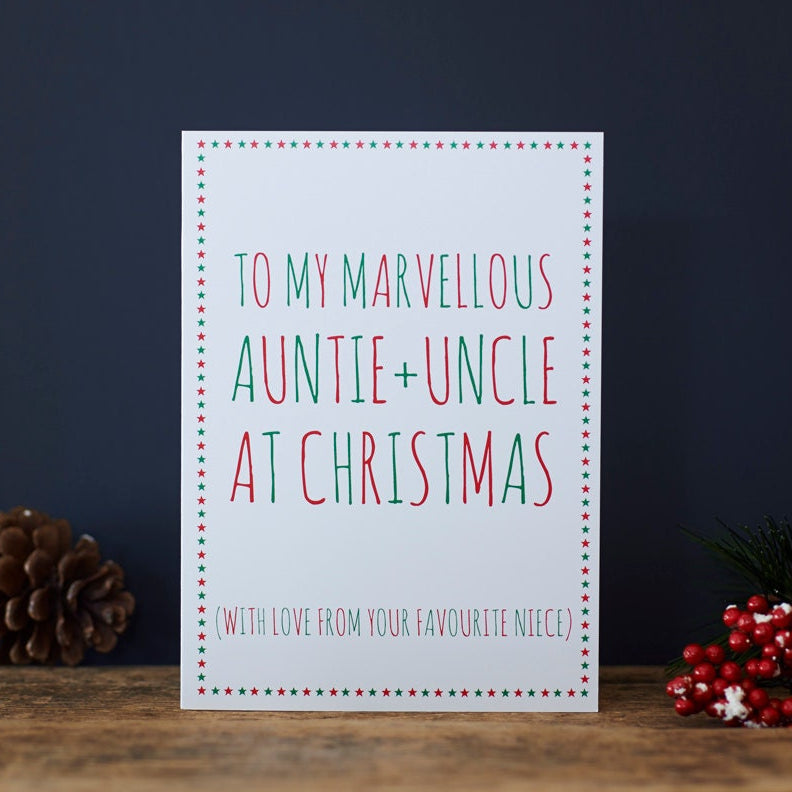 Auntie and Uncle Christmas card with red and green lettering, a star border and “With love from your favourite niece”, beside a pine cone and red berries.
