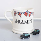 Ceramic Gramps mug with hand-drawn Union Jack bunting and two small black toy cars, a thoughtful gift for a much-loved grandparent