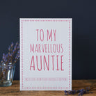 White Auntie card with pink lettering reading “To My Marvellous Auntie” and “With love from your favourite nephew”, a pink star border and dried flowers beside it.
