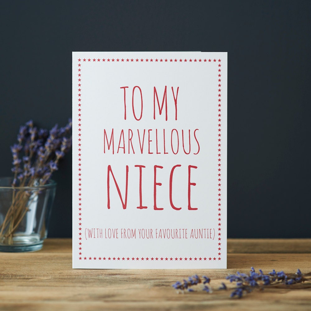 White Niece card with pink lettering reading “To My Marvellous Niece” and “With love from your favourite Auntie”, a pink star border and dried flowers beside it.